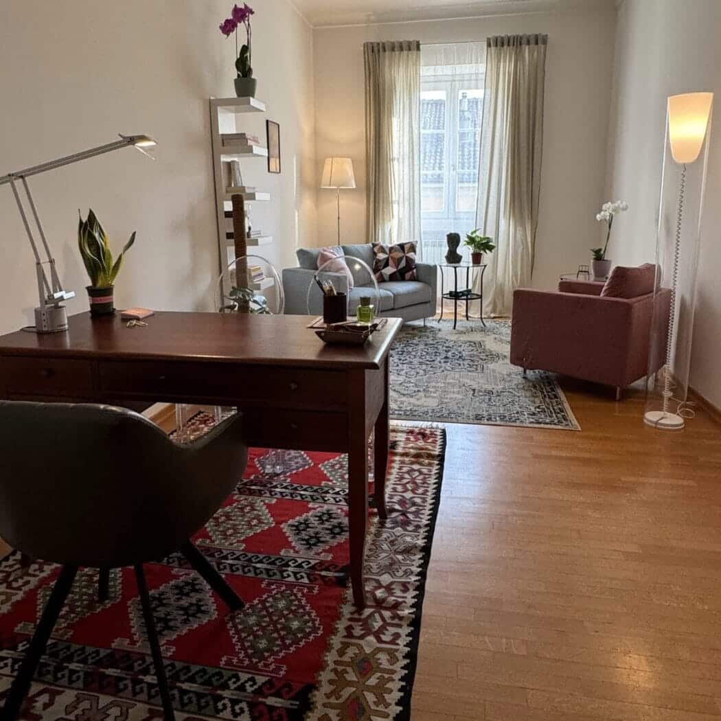Vista d’insieme dello studio psicologo Adriano Cacciola a Torino con poltrone, tappeto, piante e luce naturali.